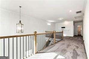 5924 Mitchell St, Flowery Branch, GA 30542 - hall with carpet flooring, crown molding, and a chandelier