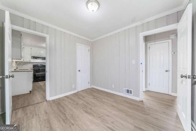 2078 Olive Springs Rd SE, Marietta, GA 30060 - empty room with crown molding, light wood-type flooring, baseboards, a sink, and a smoke detector