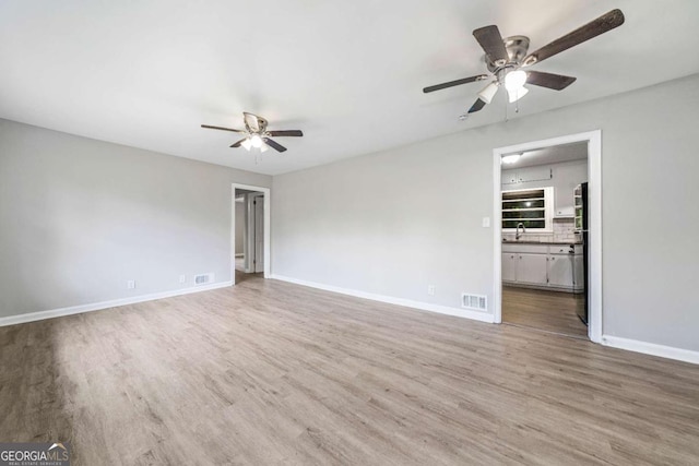 2078 Olive Springs Rd SE, Marietta, GA 30060 - spare room featuring a ceiling fan, wood finished floors, baseboards, and a sink
