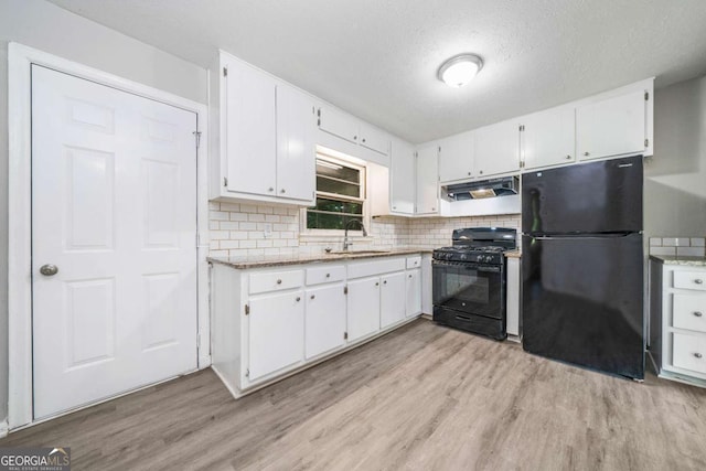 2078 Olive Springs Rd SE, Marietta, GA 30060 - kitchen featuring black appliances, a sink, light wood-style floors, white cabinets, and a textured ceiling