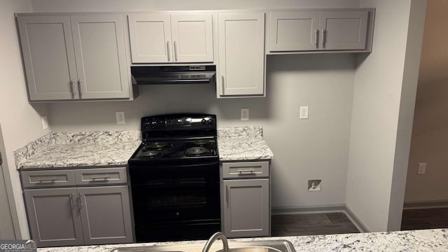 3204 Fairington Village Dr, Lithonia, GA 30038 - kitchen with black electric range oven, extractor fan, gray cabinetry, dark wood-type flooring, and light stone counters