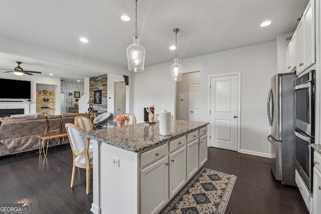 3755 Gardenside Ct, Alpharetta, GA 30004 - kitchen featuring a ceiling fan, stainless steel appliances, dark wood-style floors, a kitchen bar, and white cabinets