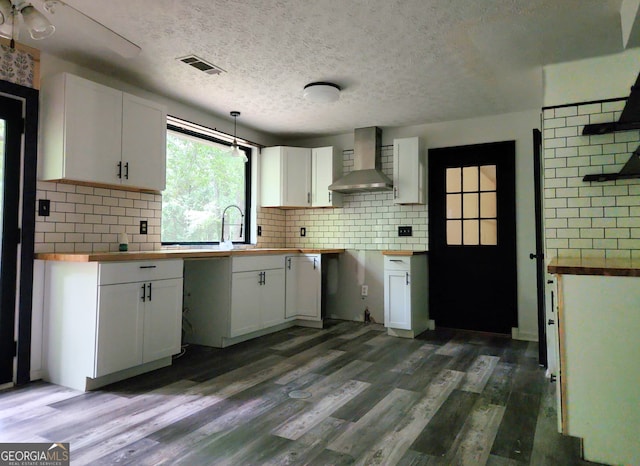 70 Priscilla Way, Newnan, GA 30265 - kitchen with wall chimney range hood, white cabinetry, backsplash, wood counters, and wood finished floors
