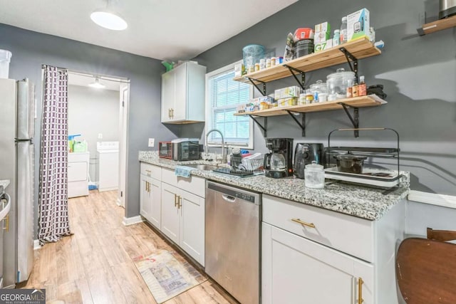 504 J C Daniel Rd, Carrollton, GA 30117 - kitchen with stainless steel appliances, light wood finished floors, washer and clothes dryer, and light stone countertops