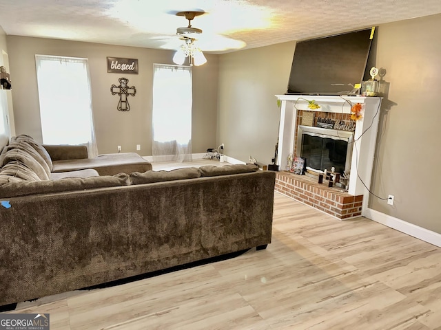 3272 Horace Rd, Bowman, GA 30624 - living area with a ceiling fan, wood finished floors, a brick fireplace, baseboards, and a textured ceiling