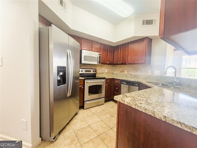 200 Renaissance Pkwy NE Unit 310, Atlanta, GA 30308 - kitchen featuring appliances with stainless steel finishes, light stone countertops, and backsplash