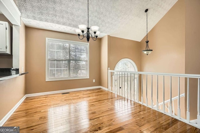 13 Cliff Ct, Villa Rica, GA 30180 - unfurnished dining area featuring hardwood / wood-style floors, a chandelier, and a textured ceiling