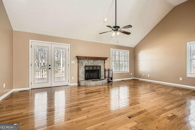 13 Cliff Ct, Villa Rica, GA 30180 - unfurnished living room featuring wood finished floors, a ceiling fan, french doors, a fireplace, and high vaulted ceiling