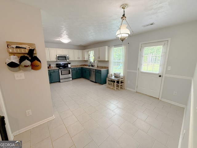 653 Al Roberts Rd, Senoia, GA 30276 - kitchen with stainless steel appliances, a sink, baseboards, decorative light fixtures, and light tile patterned flooring