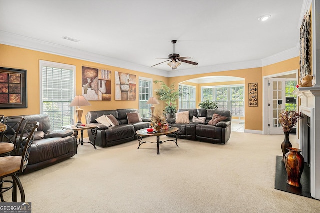 4445 Vanadium Bnd, Cumming, GA 30040 - carpeted living room featuring crown molding, a ceiling fan, a fireplace, healthy amount of natural light, and arched walkways