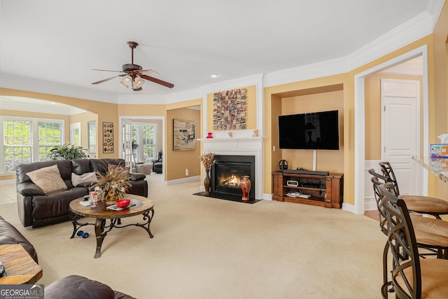 4445 Vanadium Bnd, Cumming, GA 30040 - living room with ceiling fan, a fireplace with flush hearth, ornamental molding, arched walkways, and light carpet