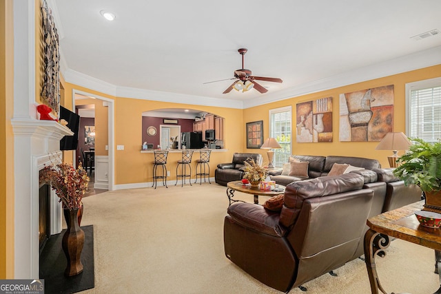 4445 Vanadium Bnd, Cumming, GA 30040 - carpeted living area featuring ceiling fan, plenty of natural light, arched walkways, crown molding, and a premium fireplace