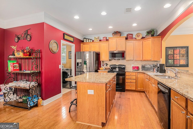 4445 Vanadium Bnd, Cumming, GA 30040 - kitchen with black appliances, a sink, ornamental molding, washer / dryer, and light wood finished floors