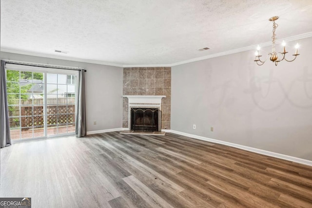 2049 Charter Ln, Lithonia, GA 30058 - unfurnished living room featuring a textured ceiling, wood finished floors, a chandelier, crown molding, and a tiled fireplace