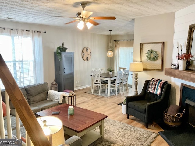 4863 Beacon Ridge Ln, Flowery Branch, GA 30542 - living area with healthy amount of natural light, ceiling fan, light wood finished floors, and a textured ceiling