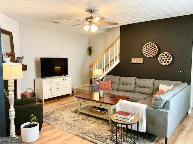 4863 Beacon Ridge Ln, Flowery Branch, GA 30542 - living room featuring ceiling fan, stairway, wood finished floors, and a textured ceiling