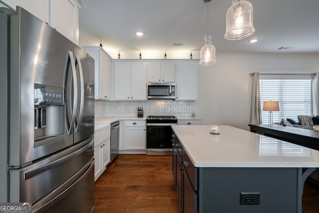 663 Oglethorpe Ave, Athens, GA 30606 - kitchen with appliances with stainless steel finishes, dark wood-style floors, a center island, backsplash, and decorative light fixtures