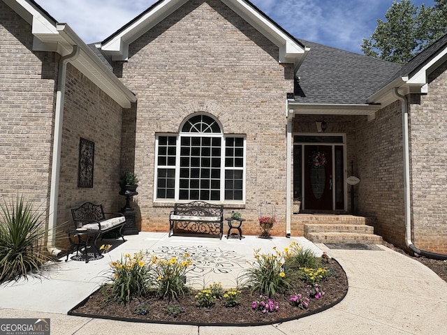 219 Periwinkle Way, Pendergrass, GA 30567 - property entrance with brick siding, a patio, and a shingled roof