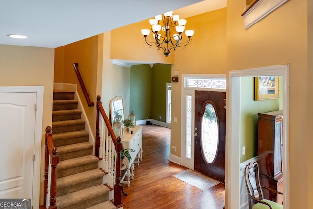 219 Periwinkle Way, Pendergrass, GA 30567 - entrance foyer featuring stairway, wood finished floors, a chandelier, a high ceiling, and baseboards
