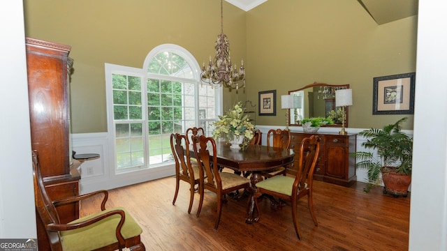 219 Periwinkle Way, Pendergrass, GA 30567 - dining area featuring a high ceiling, a chandelier, wood finished floors, a wainscoted wall, and ornamental molding