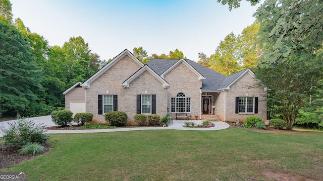 219 Periwinkle Way, Pendergrass, GA 30567 - view of front facade featuring brick siding, a front yard, and an attached garage