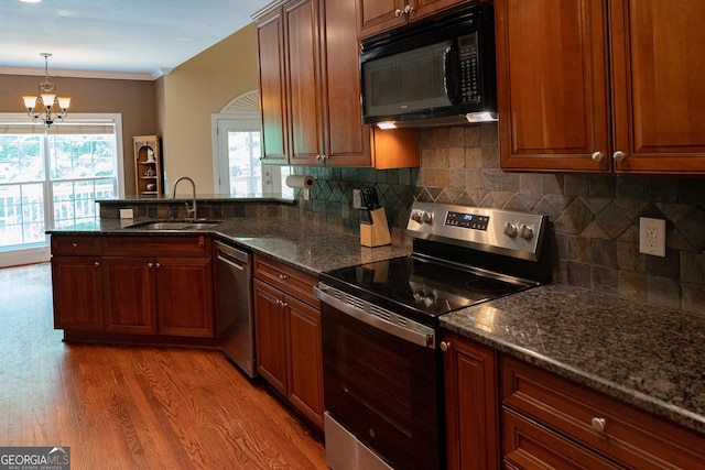 219 Periwinkle Way, Pendergrass, GA 30567 - kitchen featuring appliances with stainless steel finishes, a sink, light wood finished floors, a chandelier, and a peninsula