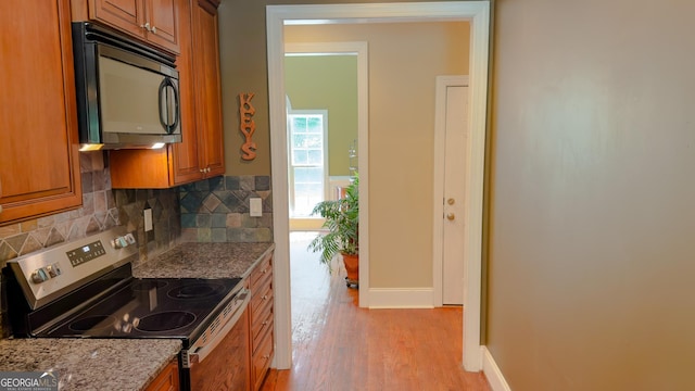 219 Periwinkle Way, Pendergrass, GA 30567 - kitchen with black microwave, stainless steel electric range, brown cabinets, and light wood finished floors