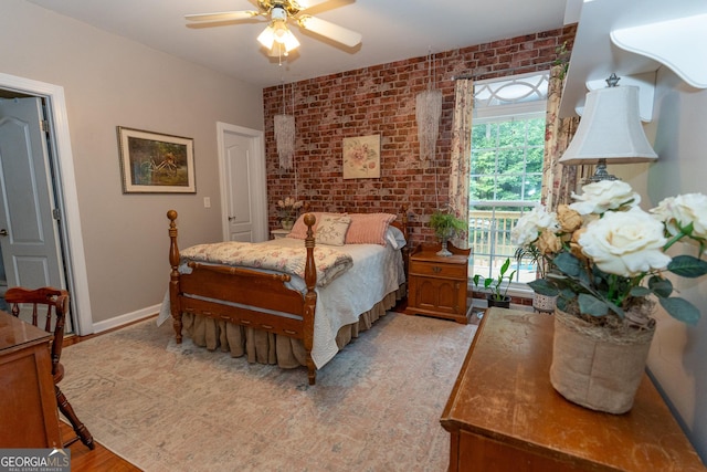 219 Periwinkle Way, Pendergrass, GA 30567 - bedroom featuring brick wall, light wood-style flooring, ceiling fan, and baseboards