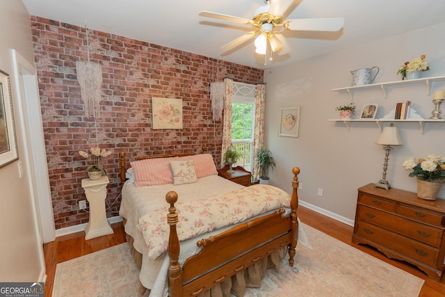 219 Periwinkle Way, Pendergrass, GA 30567 - bedroom featuring baseboards, wood finished floors, a ceiling fan, and brick wall
