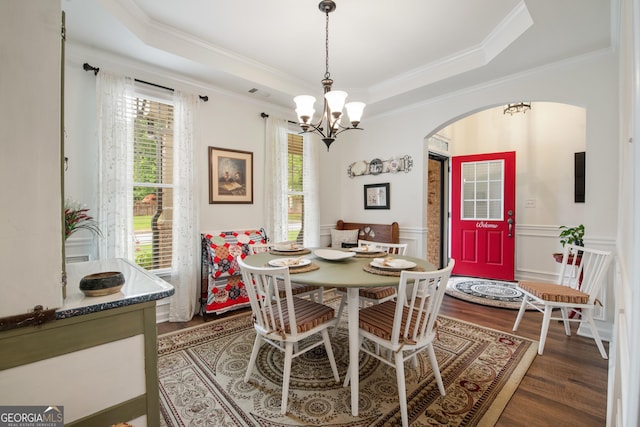 2059 Ivey Chase Dr, Dacula, GA 30019 - dining space featuring arched walkways, wood finished floors, a chandelier, crown molding, and a wainscoted wall