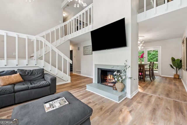 1720 Little Willeo Rd, Marietta, GA 30068 - living room featuring stairs, wood finished floors, a lit fireplace, and a towering ceiling