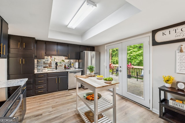 1720 Little Willeo Rd, Marietta, GA 30068 - kitchen with appliances with stainless steel finishes, a tray ceiling, light wood finished floors, decorative backsplash, and dark brown cabinets