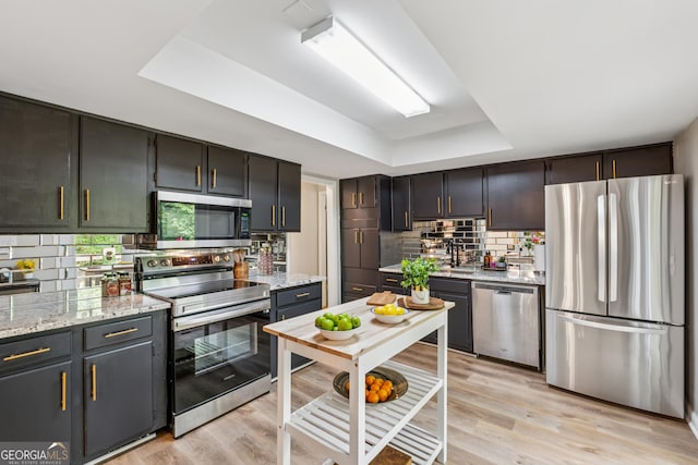 1720 Little Willeo Rd, Marietta, GA 30068 - kitchen with stainless steel appliances, a tray ceiling, backsplash, and light wood finished floors
