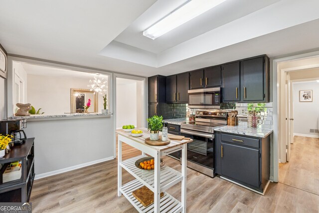 1720 Little Willeo Rd, Marietta, GA 30068 - kitchen with stainless steel appliances, light wood-style floors, decorative backsplash, a raised ceiling, and a chandelier
