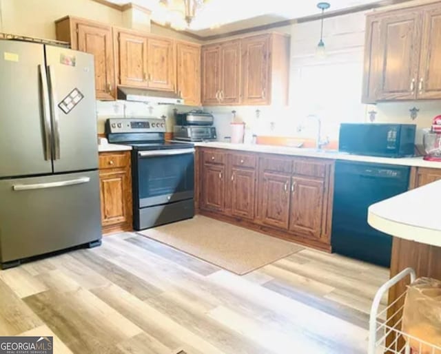 1909 Scotland Rd, Dublin, GA 31021 - kitchen featuring stainless steel appliances, light wood-style floors, light countertops, under cabinet range hood, and crown molding