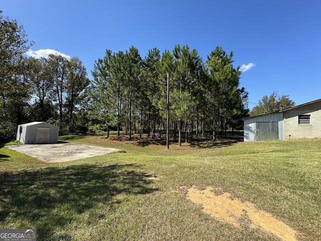1909 Scotland Rd, Dublin, GA 31021 - view of grassy yard featuring a patio area and a storage unit