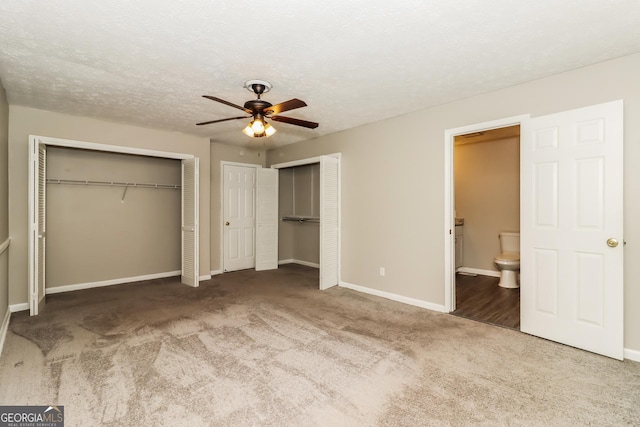 2624 Windridge Dr, Acworth, GA 30102 - unfurnished bedroom featuring two closets, carpet, connected bathroom, a ceiling fan, and a textured ceiling