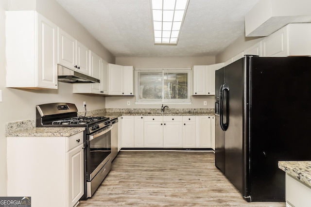 2624 Windridge Dr, Acworth, GA 30102 - kitchen with stainless steel appliances, under cabinet range hood, light wood-style flooring, white cabinetry, and light stone counters