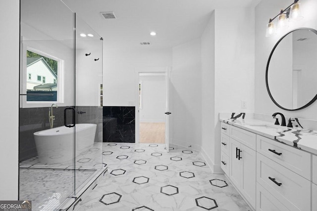 83 Beech Creek Cir, Winder, GA 30680 - full bath with vanity, marble look tiles, a soaking tub, tile walls, and recessed lighting