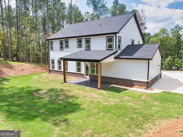 83 Beech Creek Cir, Winder, GA 30680 - back of property featuring a shingled roof, a patio, brick siding, and a lawn