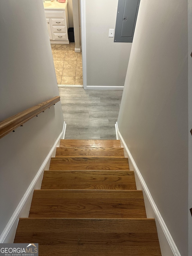 1214 Tucker Rd, Perry, GA 31069 - stairway featuring electric panel, baseboards, and wood finished floors