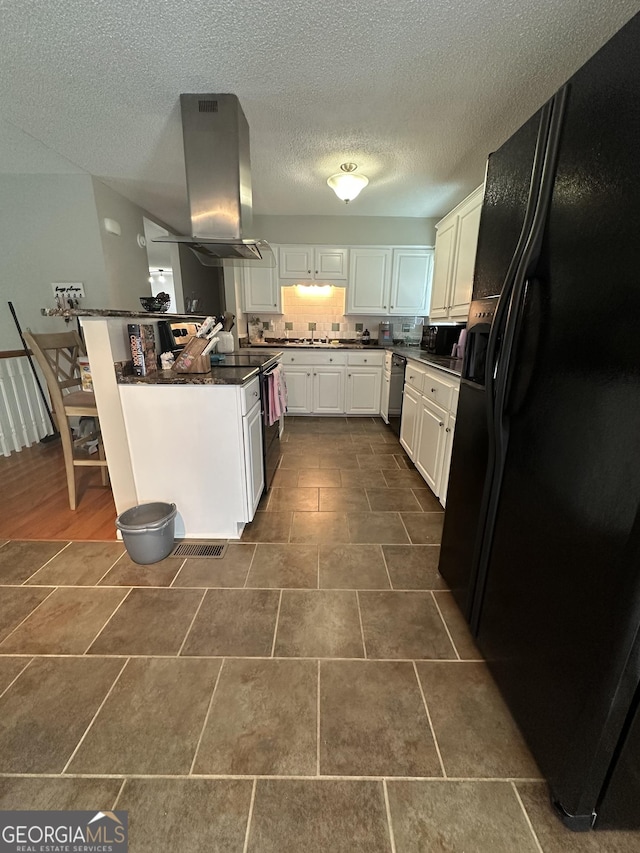 1214 Tucker Rd, Perry, GA 31069 - kitchen featuring black appliances, island exhaust hood, dark countertops, white cabinets, and a textured ceiling