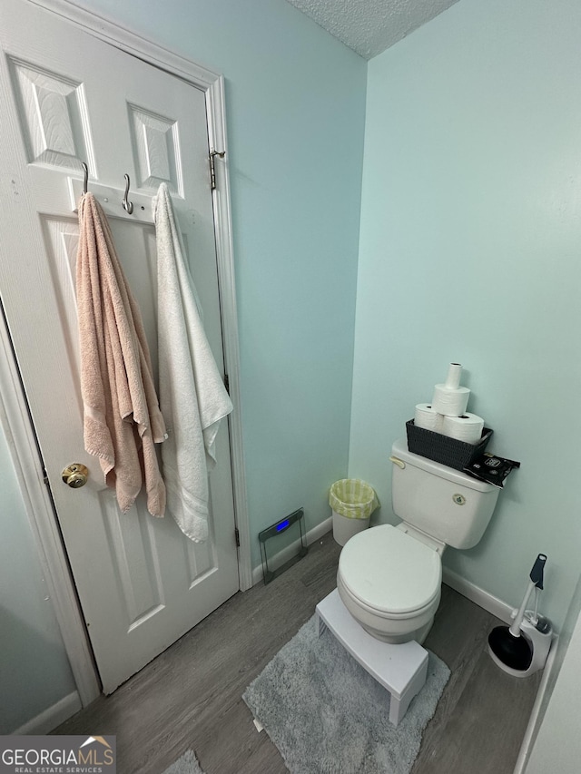1214 Tucker Rd, Perry, GA 31069 - bathroom featuring toilet, wood finished floors, baseboards, and a textured ceiling