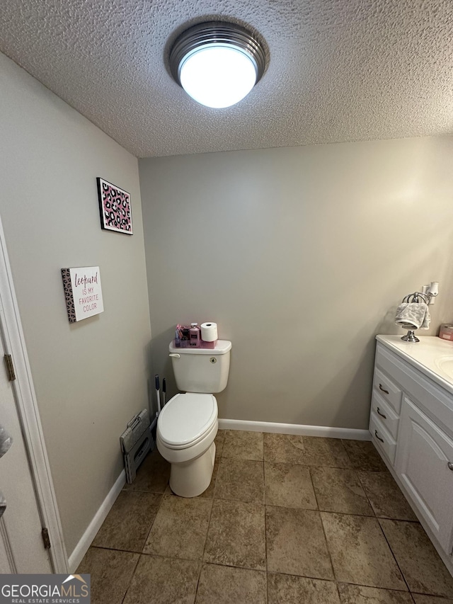 1214 Tucker Rd, Perry, GA 31069 - bathroom featuring a textured ceiling, vanity, toilet, and baseboards