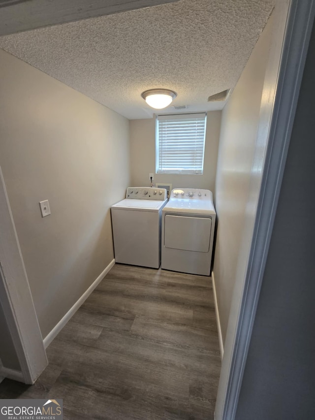 1214 Tucker Rd, Perry, GA 31069 - washroom featuring washer and clothes dryer, baseboards, a textured ceiling, and wood finished floors