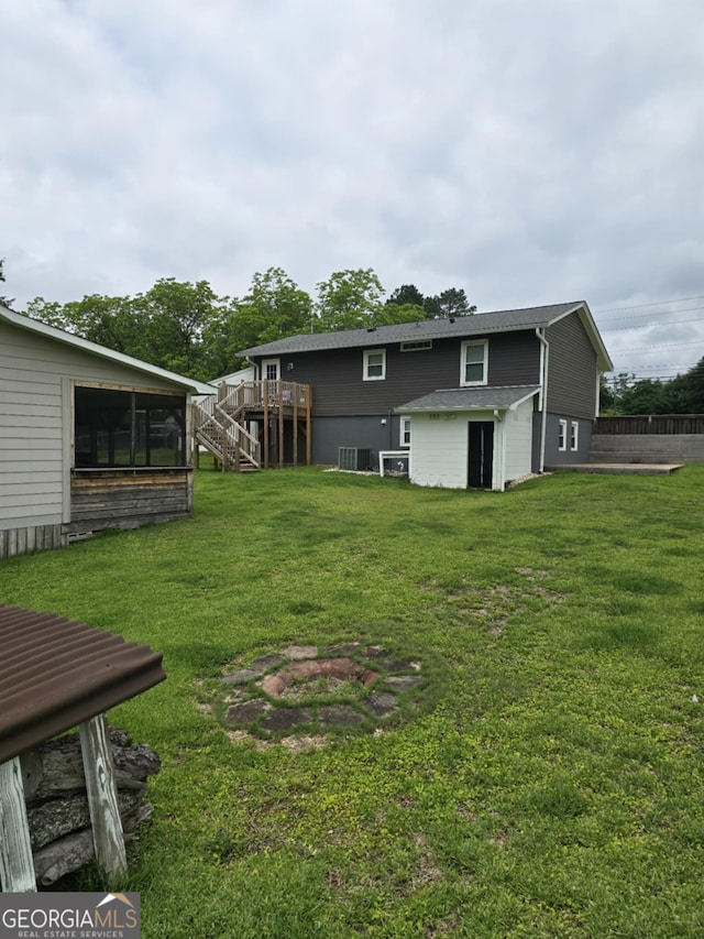 1214 Tucker Rd, Perry, GA 31069 - view of green lawn featuring stairway, a sunroom, an outdoor fire pit, and cooling unit