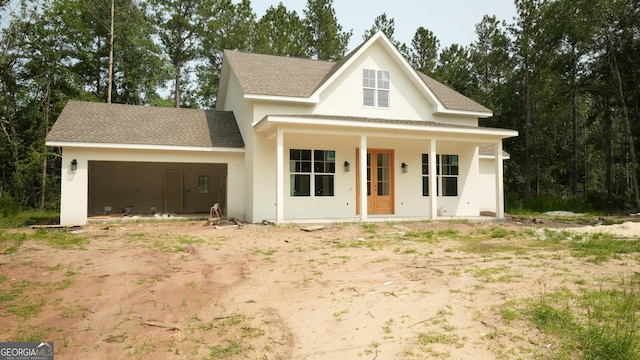 5016 Smith Rd SE, Townsend, GA 31331 - modern farmhouse featuring an attached garage, a shingled roof, dirt driveway, stucco siding, and covered porch