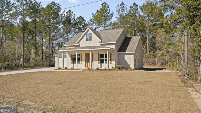 5016 Smith Rd SE, Townsend, GA 31331 - modern farmhouse featuring a porch, stucco siding, driveway, a garage, and a shingled roof