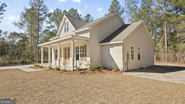 5016 Smith Rd SE, Townsend, GA 31331 - view of front of property featuring covered porch, roof with shingles, and stucco siding