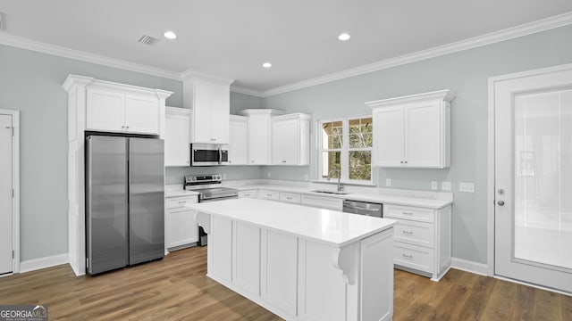 5016 Smith Rd SE, Townsend, GA 31331 - kitchen with appliances with stainless steel finishes, white cabinetry, light countertops, a kitchen island, and dark wood finished floors